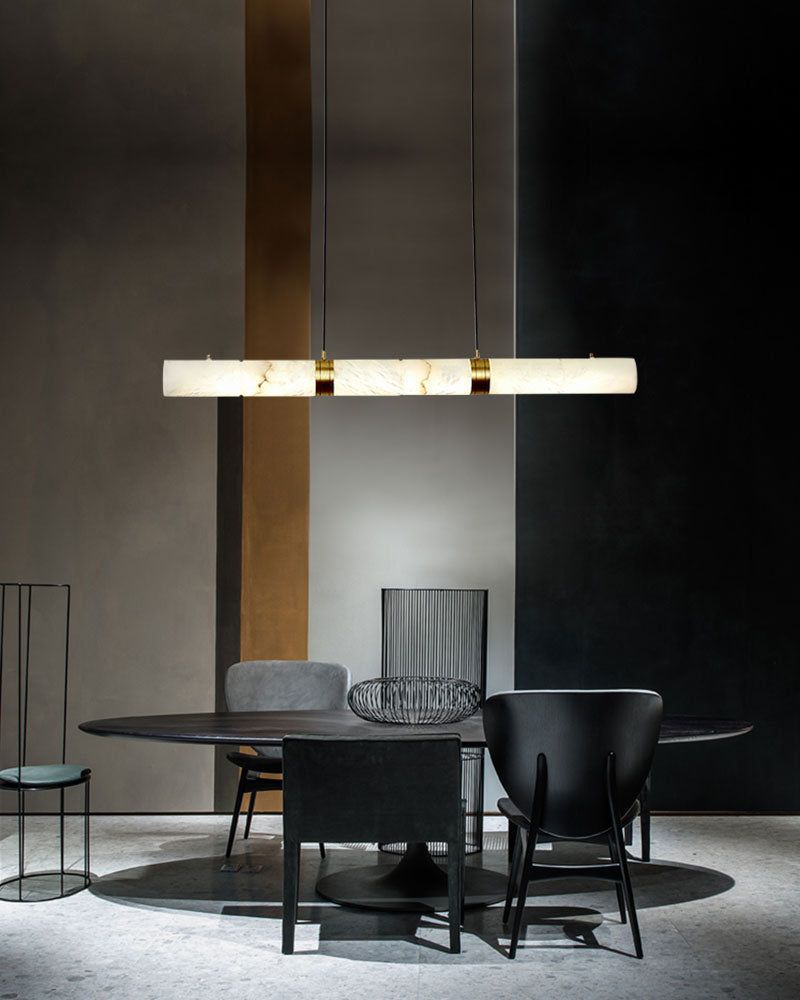 Sleek dining room with a round table, black chairs, and alabaster LED pendant lamp.