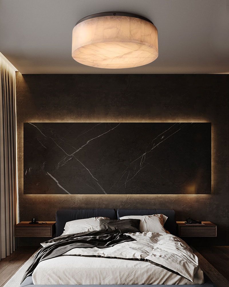 Warm alabaster ceiling light over minimalist bedroom with dark accent wall.