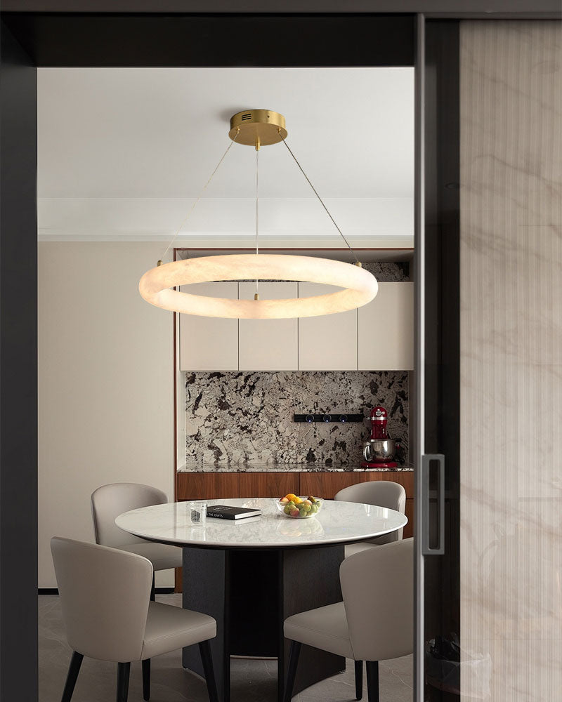 Sleek marble ring LED pendant light above modern round dining table in stylish kitchen.