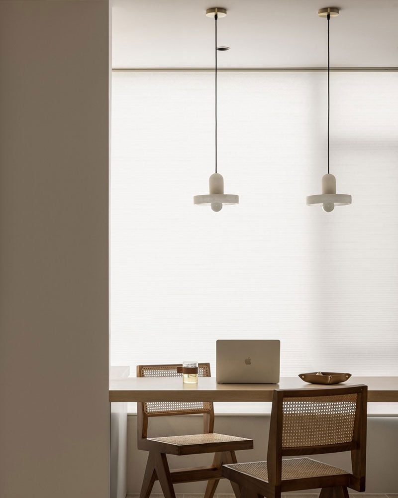 E27 alabaster pendant lamps illuminating a minimalist dining area with wooden furniture