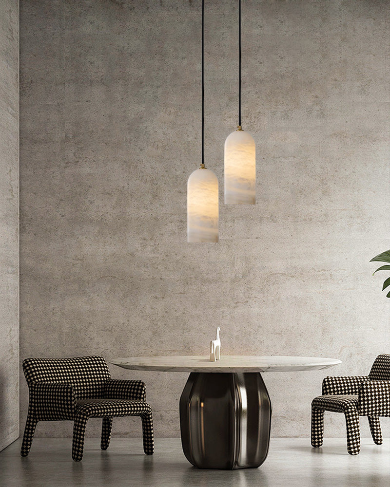 Contemporary dining space with round marble table and minimalist marble pendant lamps.