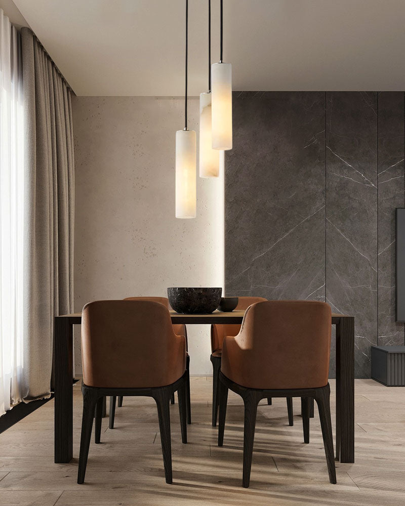 Alabaster pendant lamps over a modern dining table with brown chairs and elegant decor.