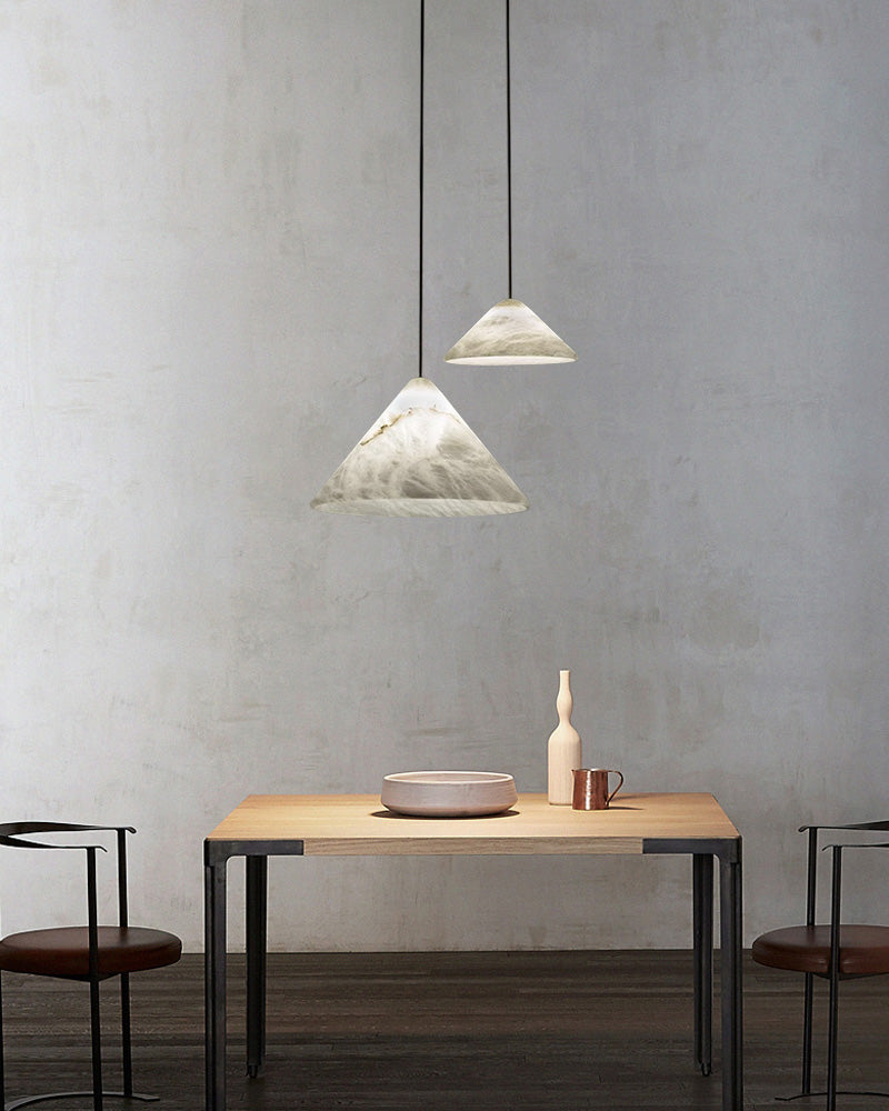 Minimalist dining table with two alabaster pendant lamps overhead in modern decor.