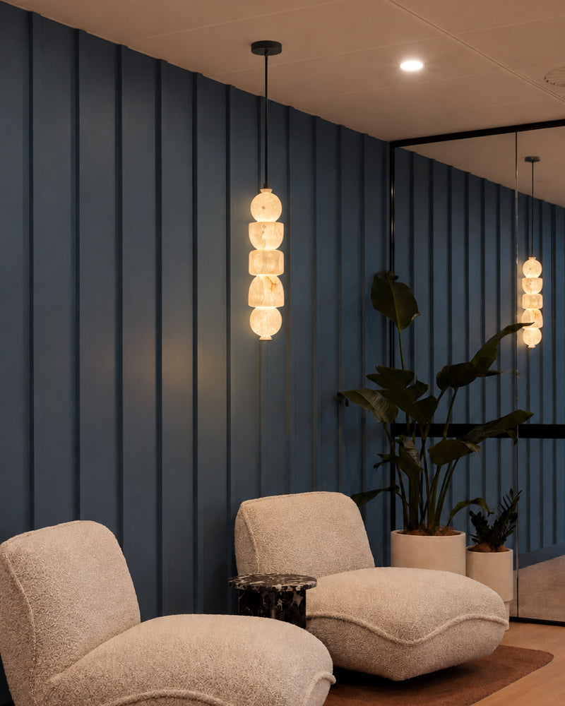 Globe pendant light cluster with warm alabaster-style glass shades on black cord