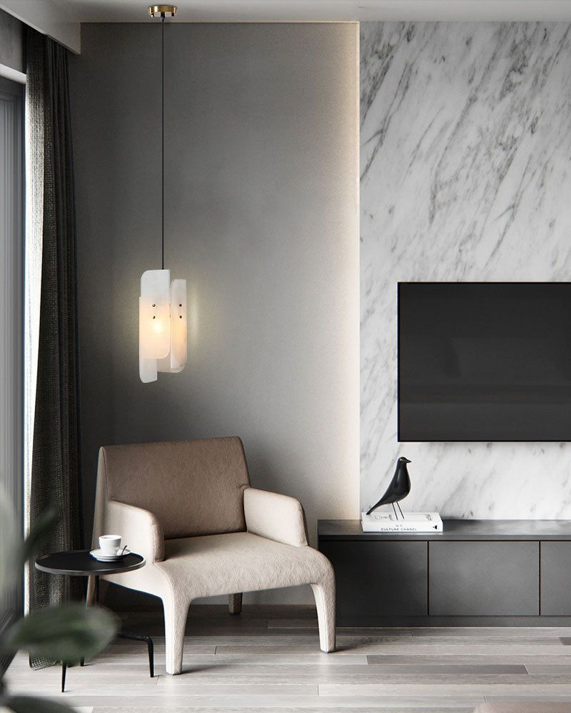 Stylish living space featuring a white marble wall, minimalist chair, and alabaster pendant lamp.