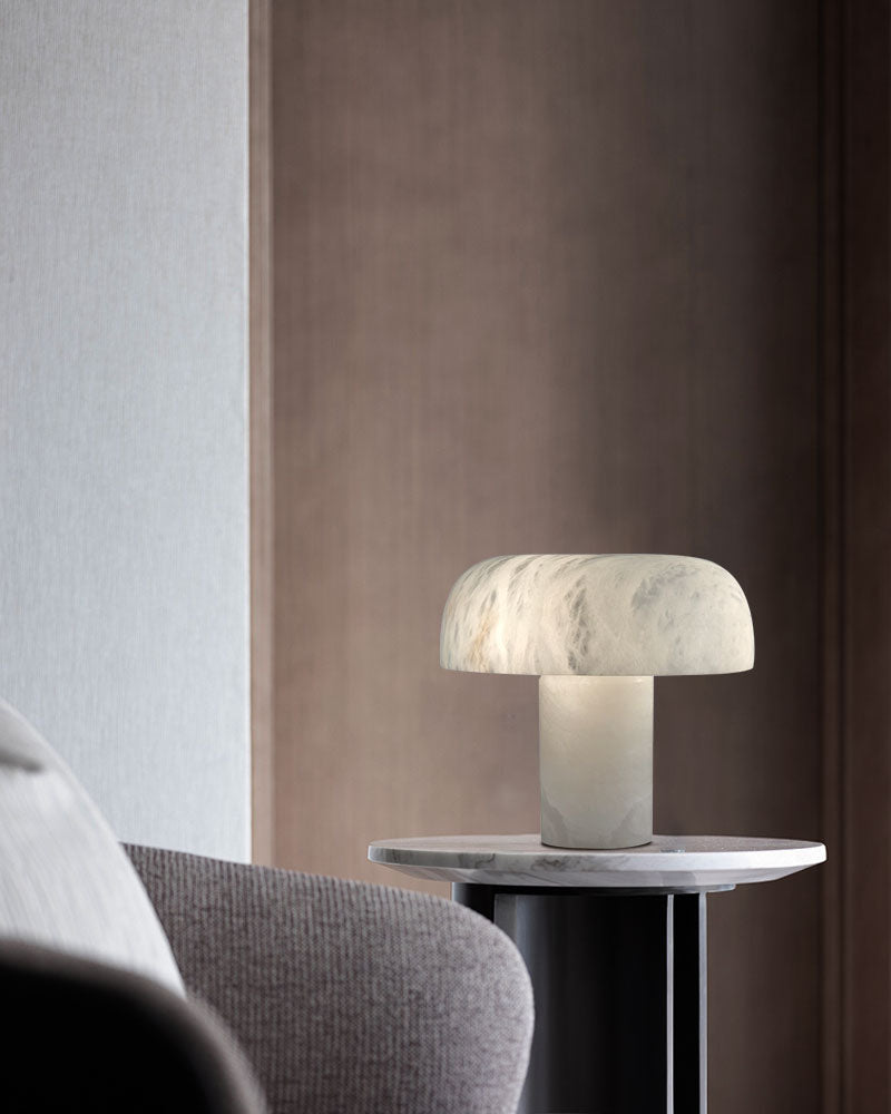 White marble table lamp with rounded shade on sleek side table in modern living room.