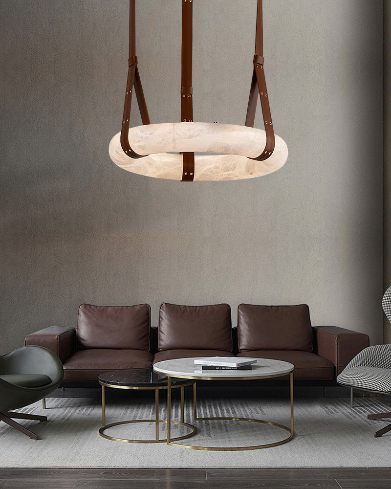 Alabaster LED pendant lamp with leather straps over modern living room furniture.