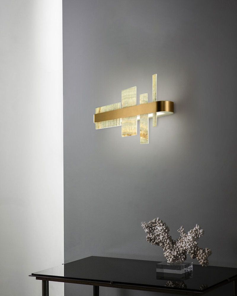 Gold and marble wall sconce enhancing modern decor with soft illumination.