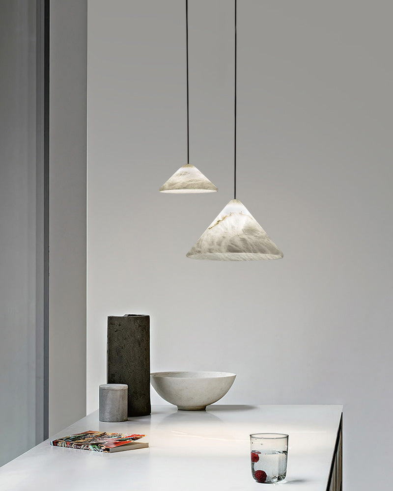 Alabaster pendant lamps in minimalist decor above a stylish white table with modern accents.