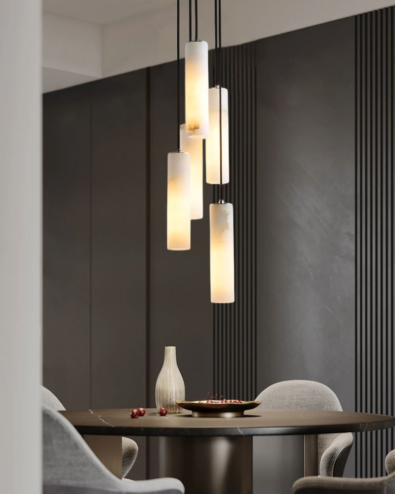 Elegant alabaster pendant lamps above a dark dining table, creating a stylish dining ambiance.