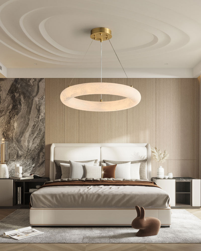 Sleek slim marble ring LED pendant light above modern bed in elegant bedroom.