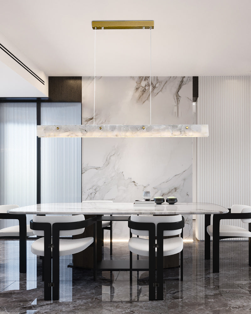 Nordic marble linear pendant light above a sleek black and white dining table.