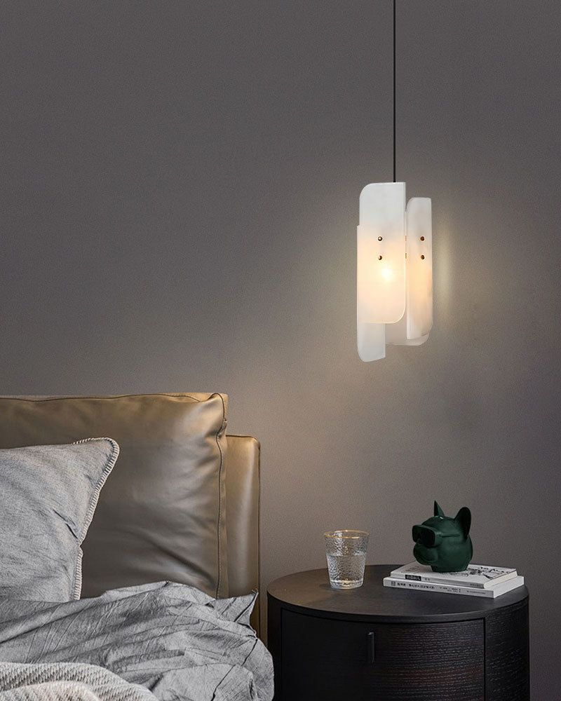 Minimalist bedroom with alabaster pendant lamp and grey bedding, soft lighting ambiance.