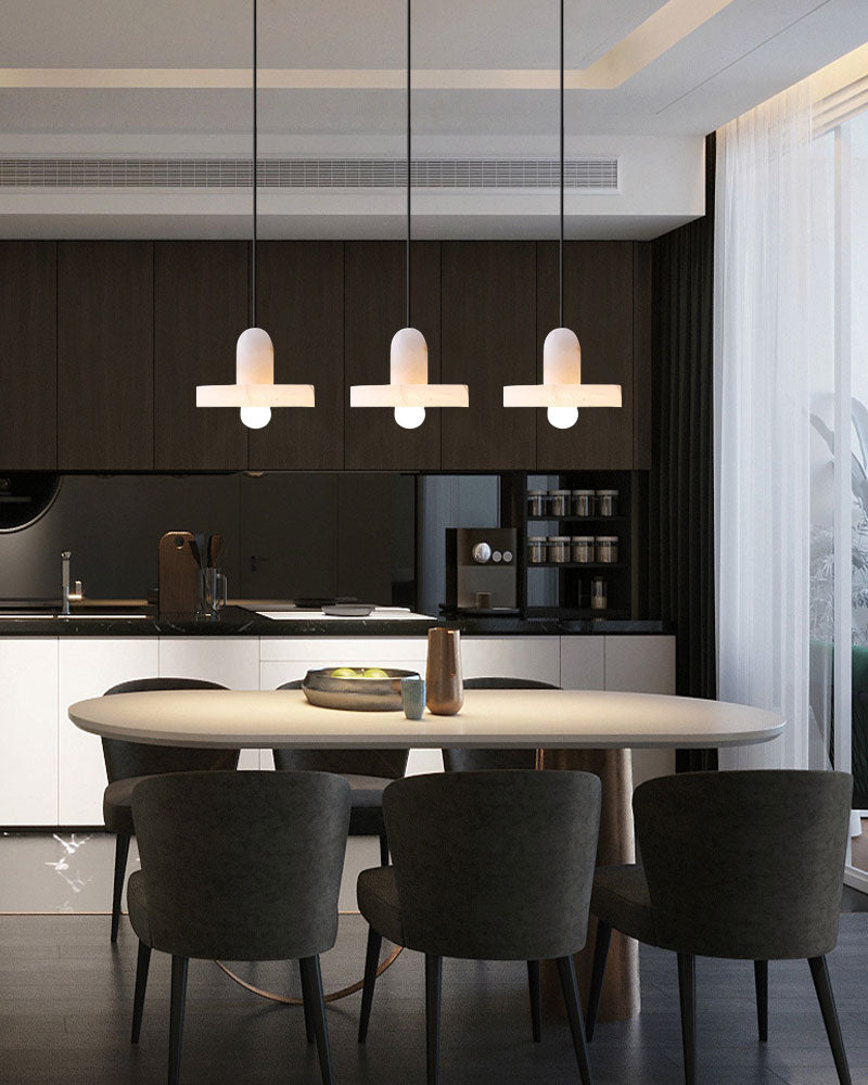 Alabaster pendant lights above a round dining table in a modern kitchen interior