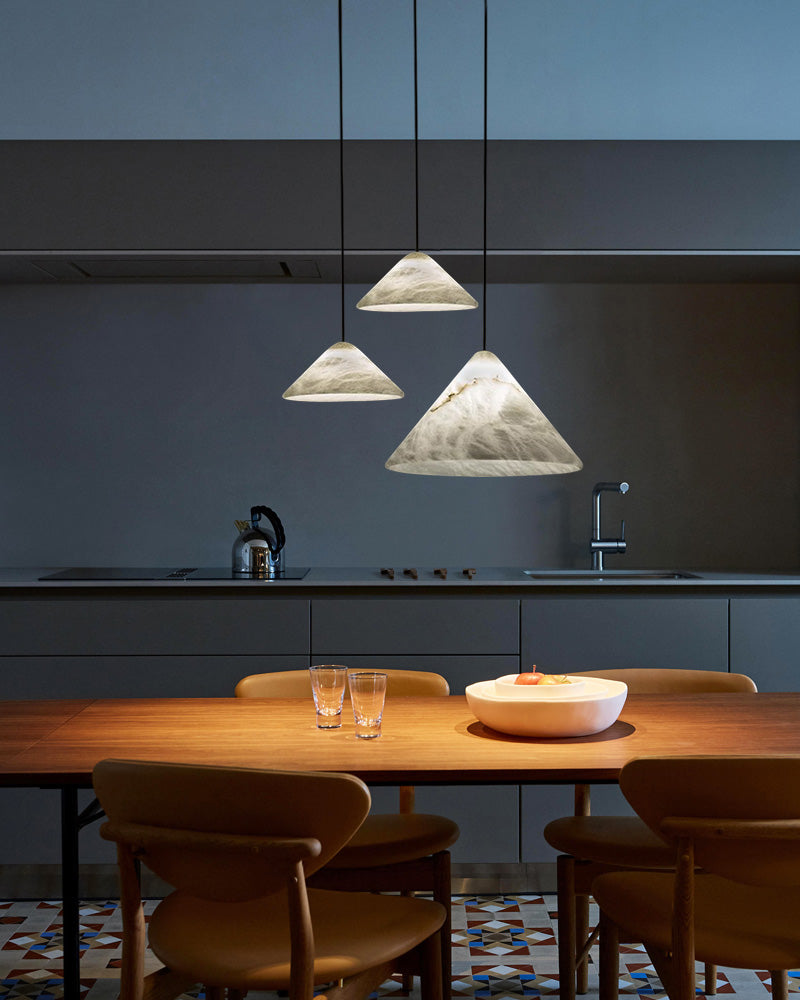 Minimalist dining area featuring alabaster pendant lamps above a wooden table.