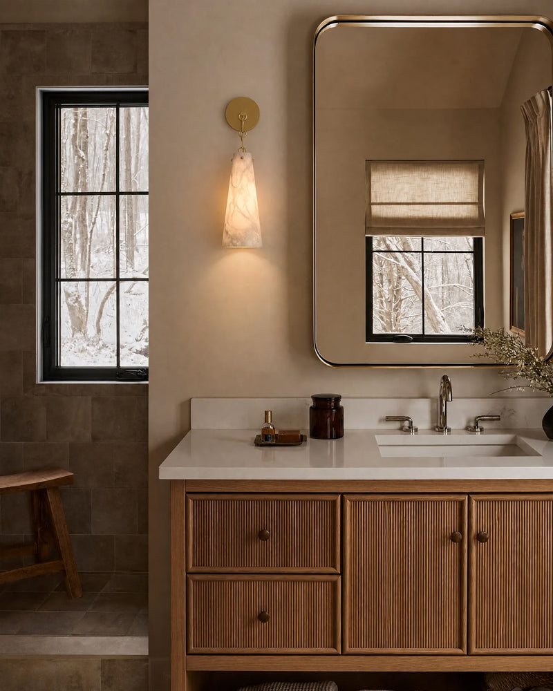Alabaster conical wall sconce with brass-toned backplate, warm light