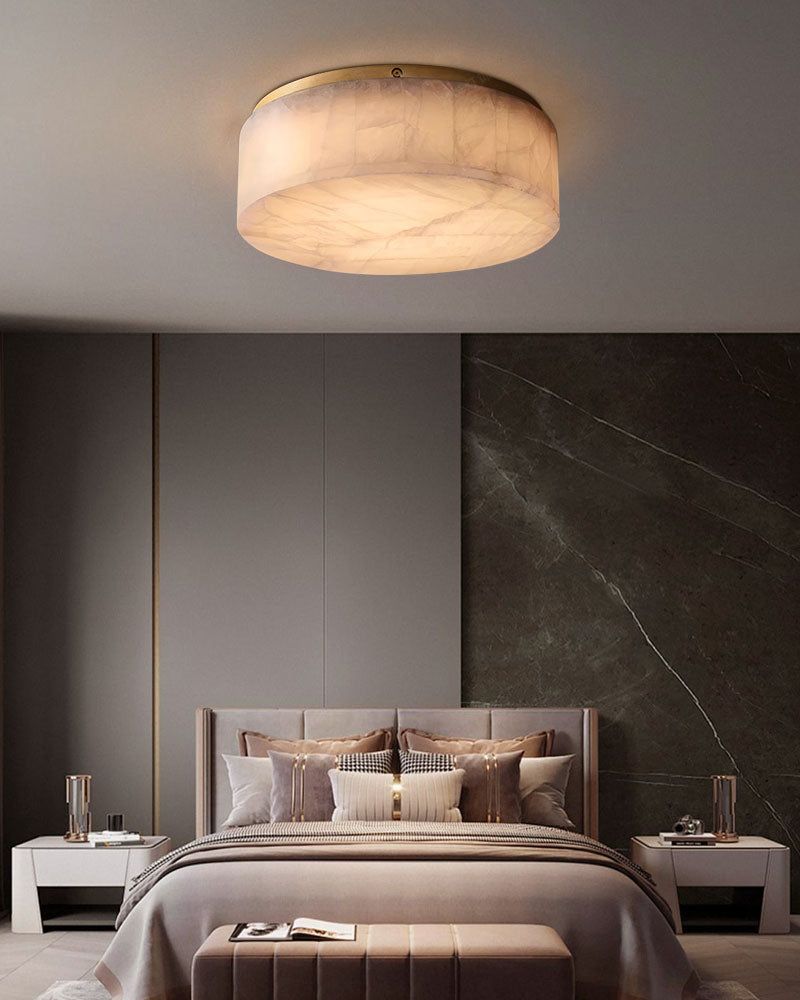 Round alabaster ceiling light casting soft glow in modern bedroom with stylish decor.