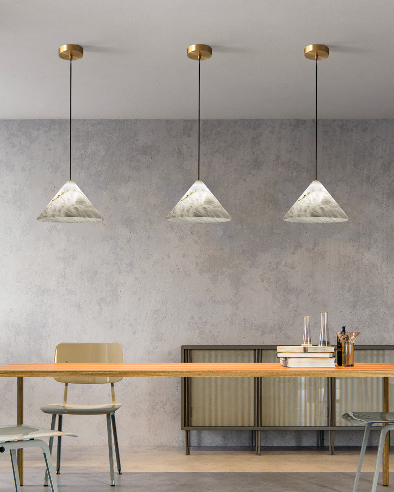 Three conical alabaster pendant lamps illuminating a sleek modern dining area.