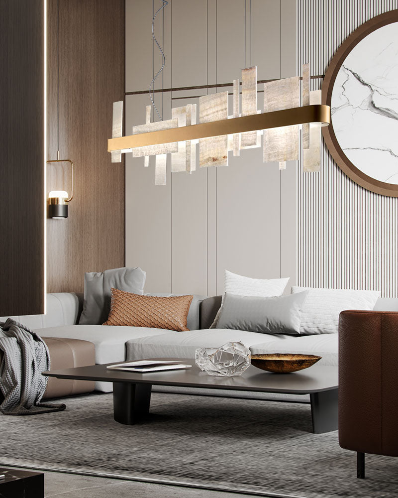 Long marble slice chandelier illuminating a chic modern living room above a dark coffee table.