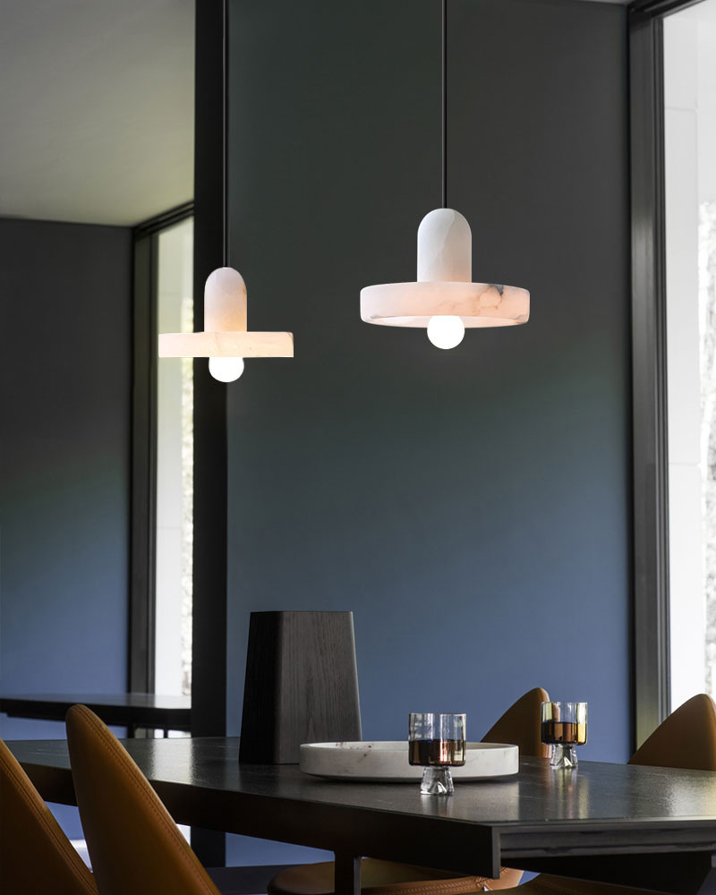 Two modern E27 alabaster pendant lights above a sleek dining table in a chic interior.