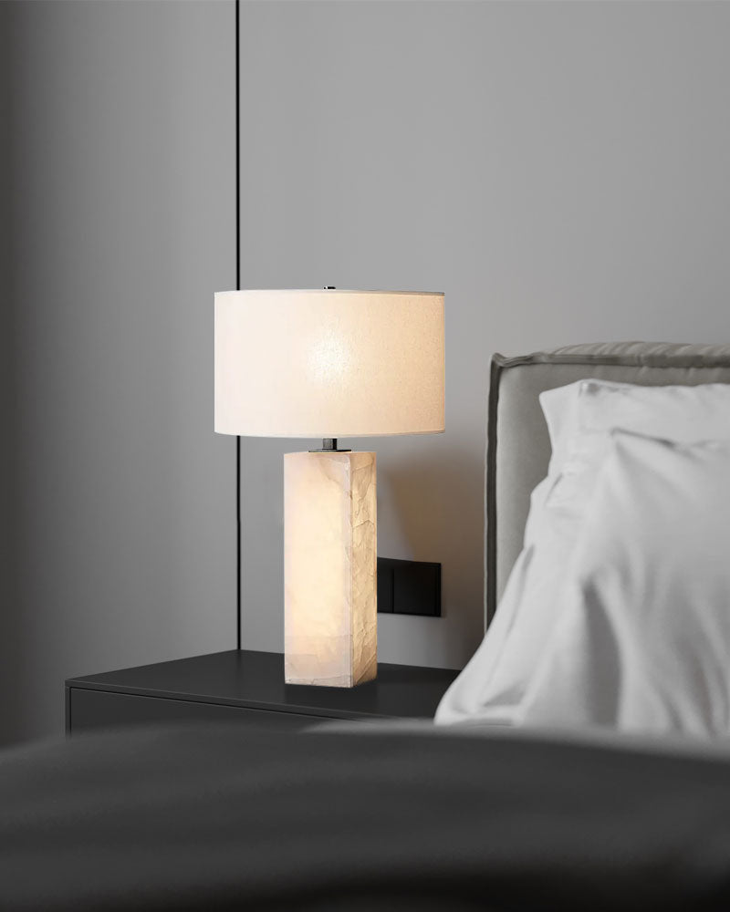 Alabaster marble table lamp with white fabric shade on nightstand in modern bedroom