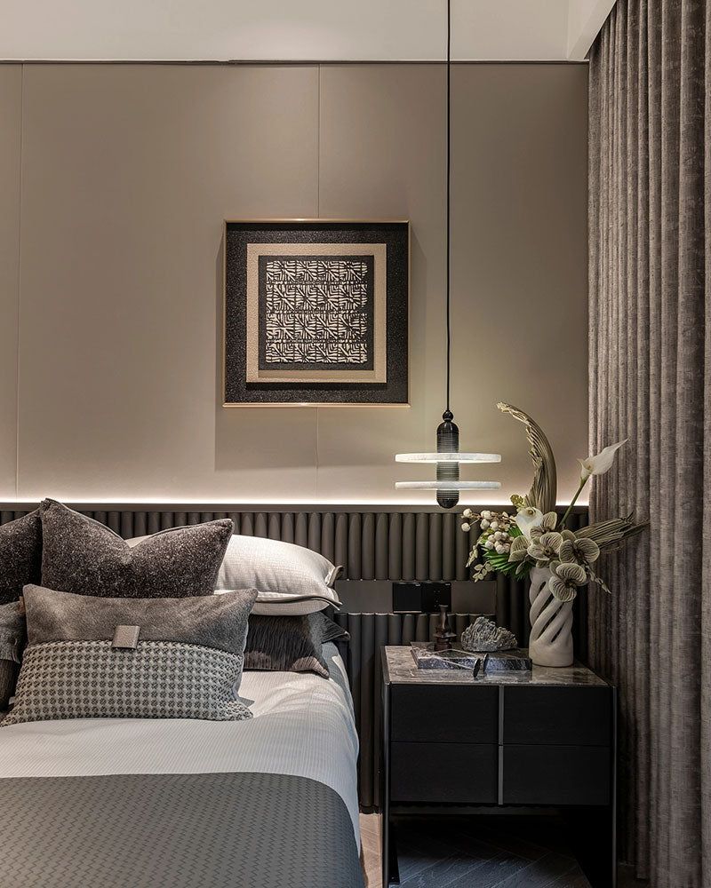 Sleek pendant lamp above nightstand with decor in modern bedroom design