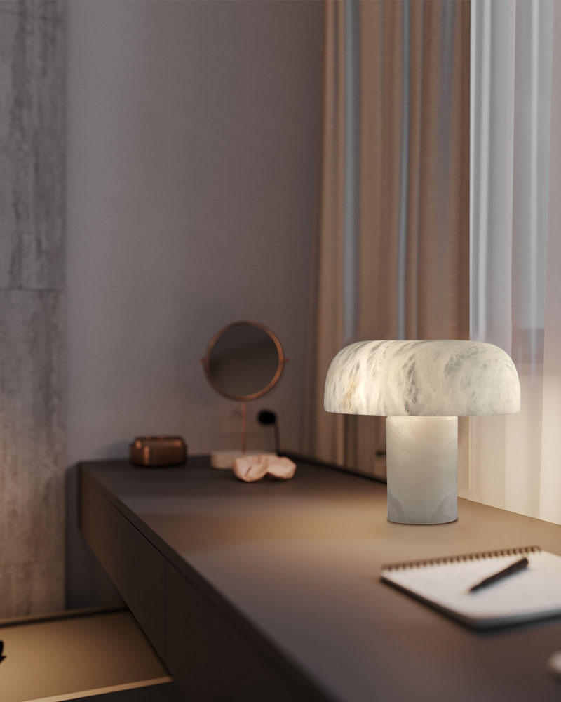 White marble stone table lamp with rounded shade illuminating a modern desk space.