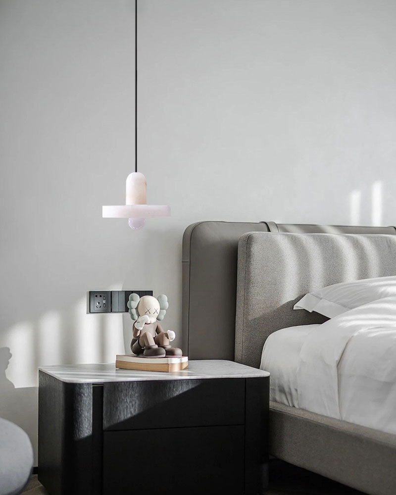 Modern E27 alabaster pendant light above a bedside table in a chic bedroom.