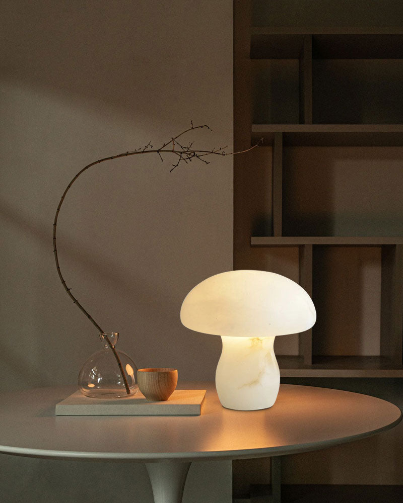 White mushroom table lamp casting warm light in cozy interior setting.