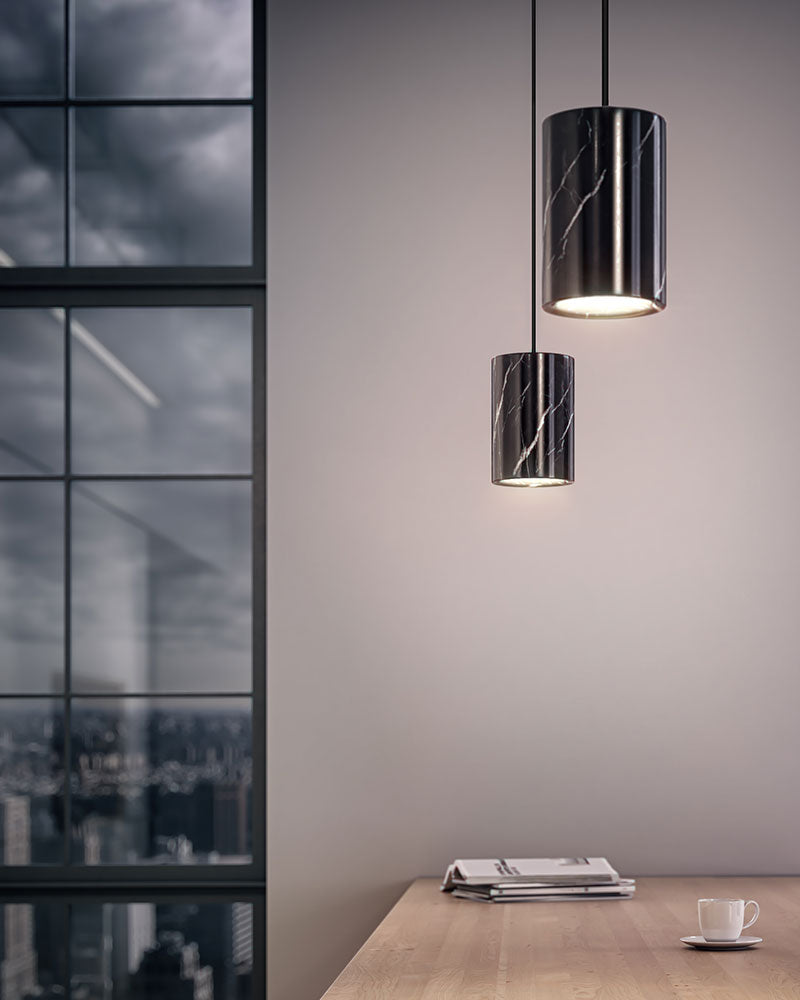 Black marble pendant lamps over wooden table with city skyline view.