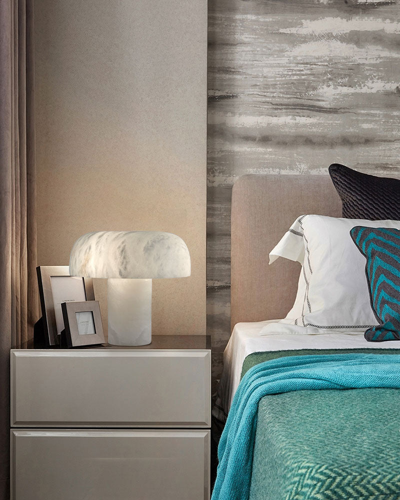 Stylish white marble table lamp on a nightstand in a chic modern bedroom.