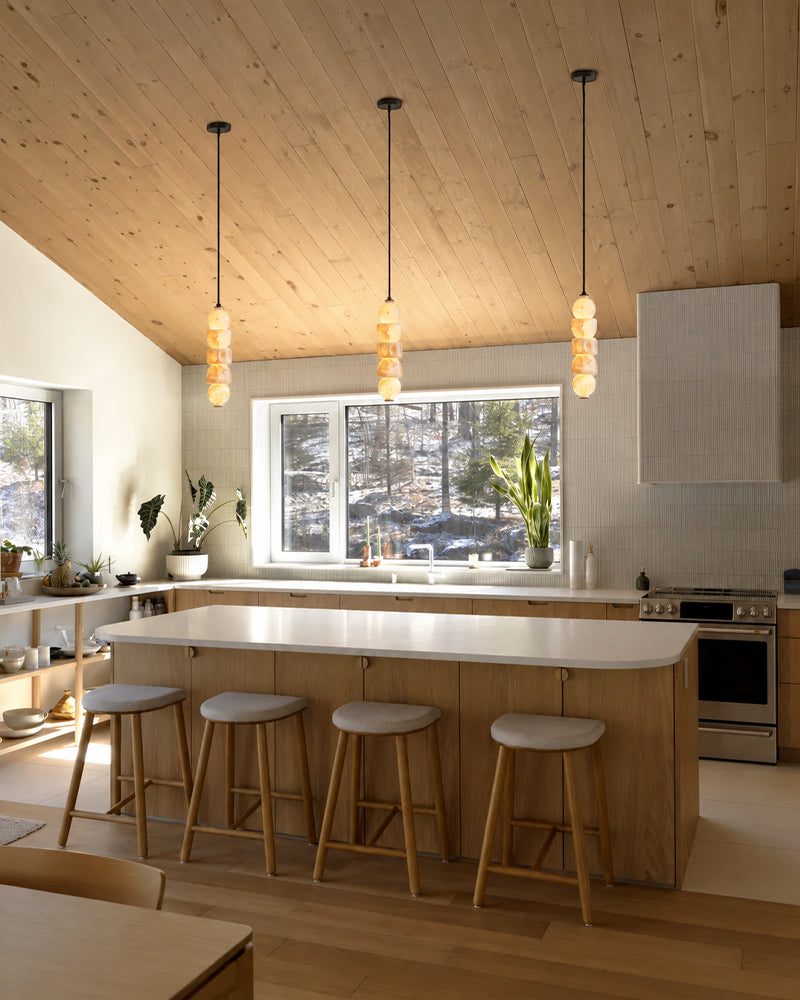Multiple globe pendant lights with stacked alabaster-style glass shades in a kitchen