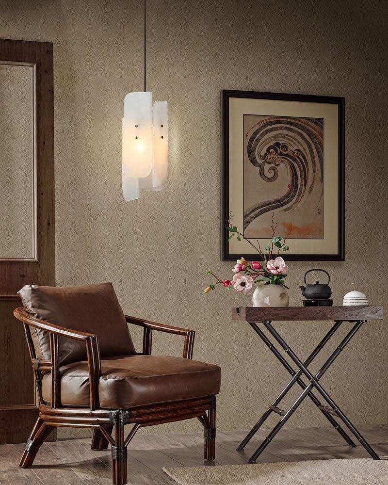 Cozy seating corner with an alabaster pendant lamp and brown armchair against an art piece.