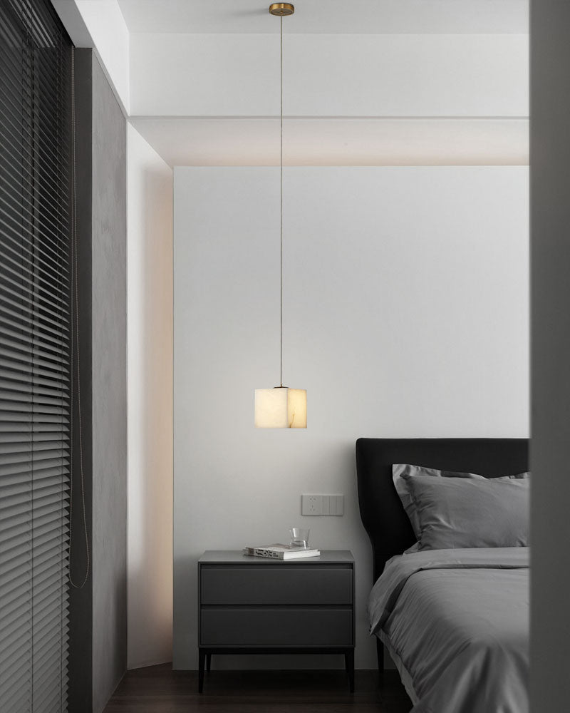 Square white alabaster pendant chandelier above modern bedside table in minimalist bedroom