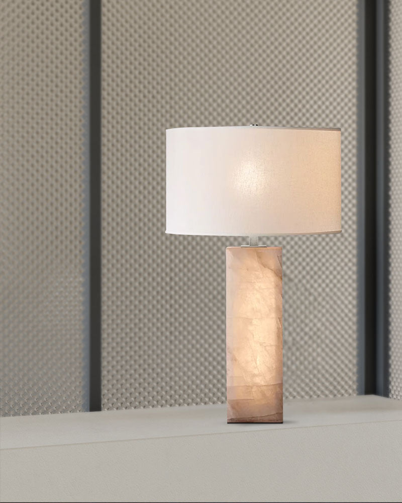 Vintage alabaster table lamp with white shade on table against textured background