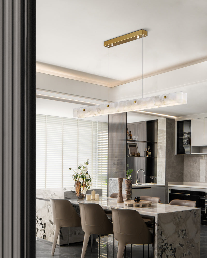 Marble pendant light over a modern kitchen island with elegant chairs