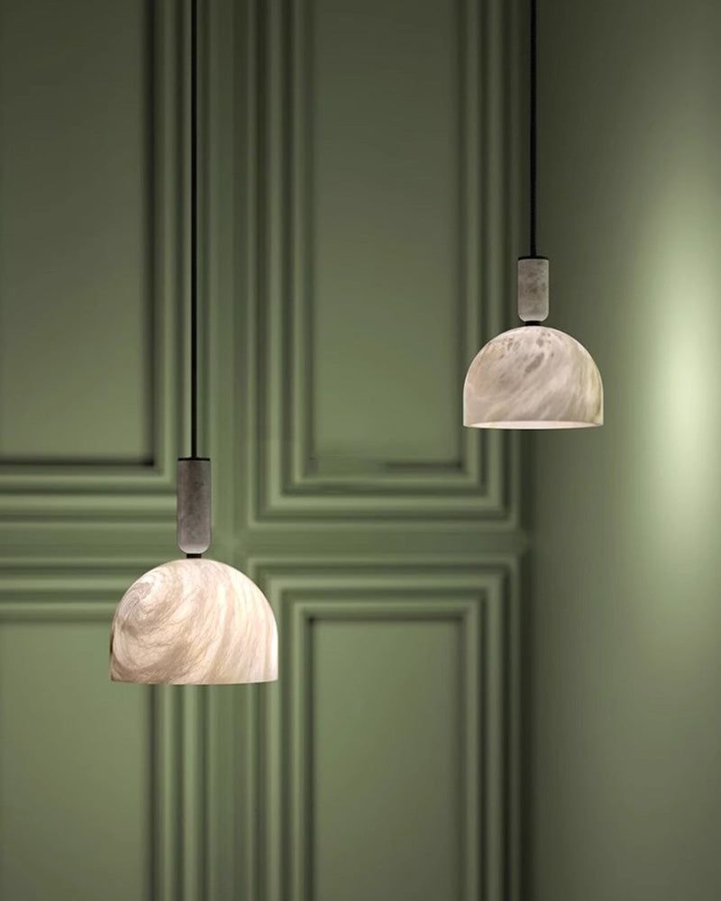 Postmodern white marble pendant lights against a stylish green wall.