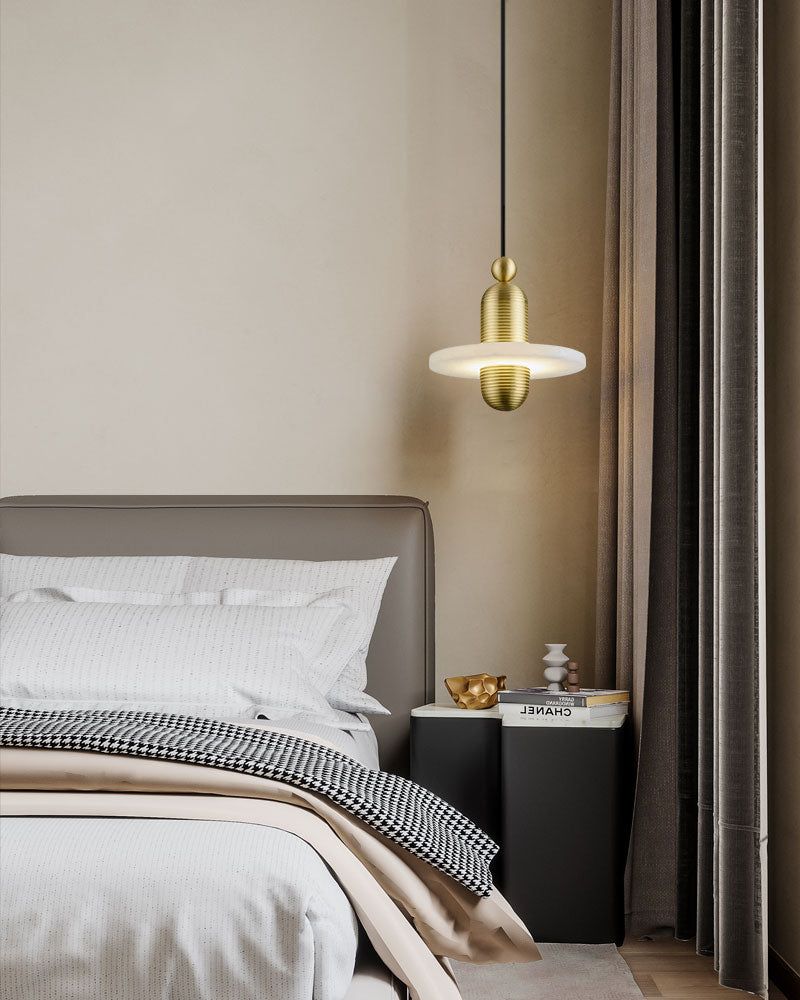 Brass and glass pendant lamp illuminating stylish bed in modern bedroom decor
