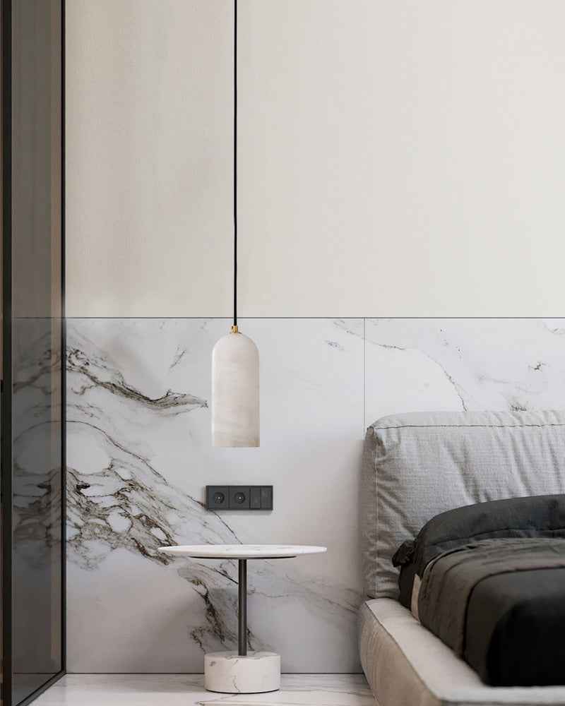 Minimalist bedroom with marble pendant lamp, marble side table, and gray bedding.