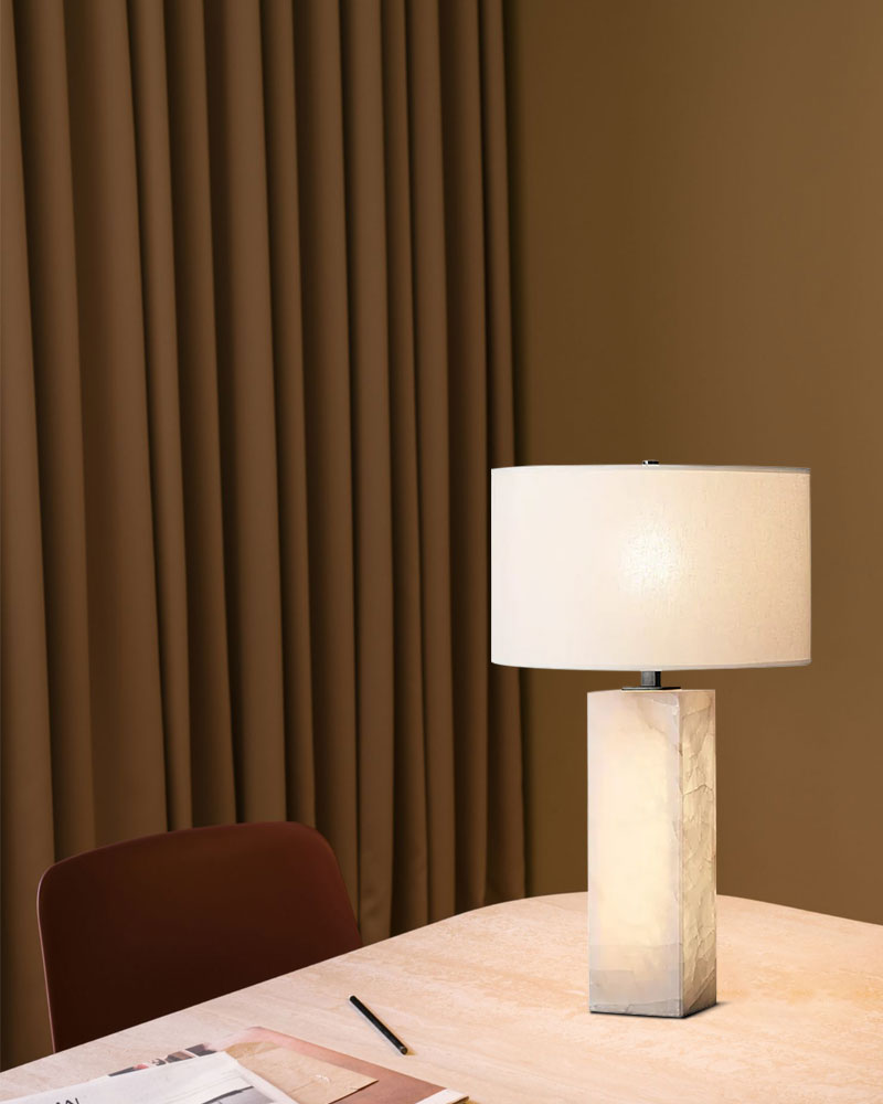 Alabaster marble table lamp with fabric shade on table in contemporary interior setting