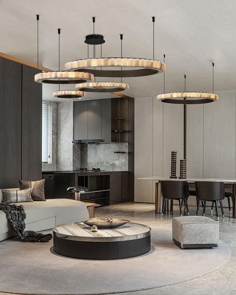 Three-tiered alabaster pendant lamps above modern living room seating and dining area.