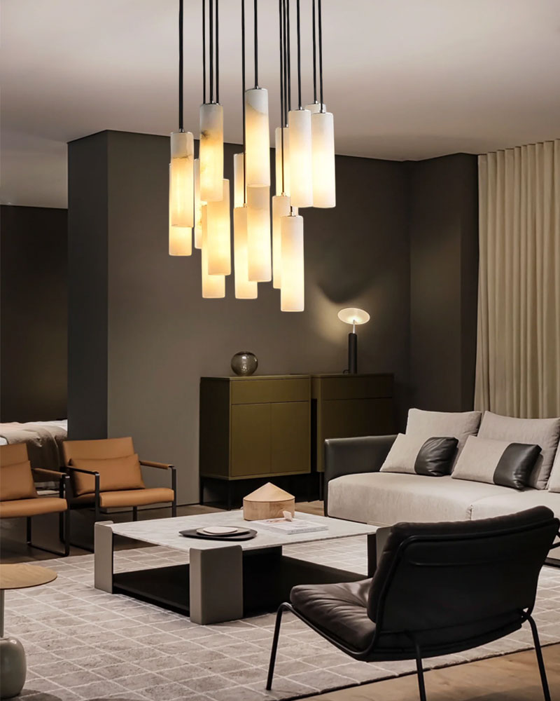 Multiple alabaster pendant lamps in a chic living room with a sofa and coffee table.