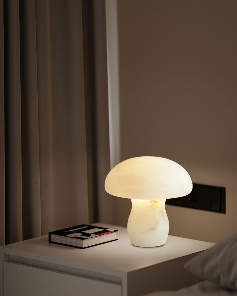 White mushroom lamp softly illuminating nightstand with book in cozy bedroom.