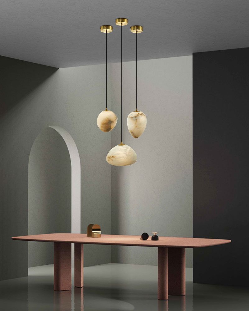 Trendy dining area with G9 Alabaster Pebble pendant lights over a modern table.