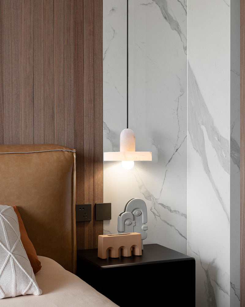 Modern E27 alabaster pendant light above bedside table in contemporary bedroom.