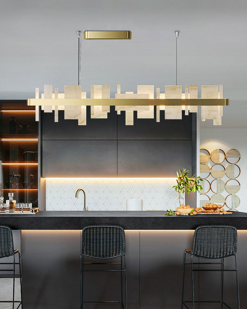 Marble slice and metal chandelier above sleek kitchen island with modern decor.