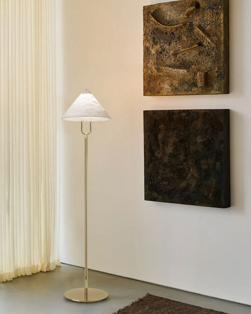 Alabaster conical floor lamp with metal rod in minimalist room with art
