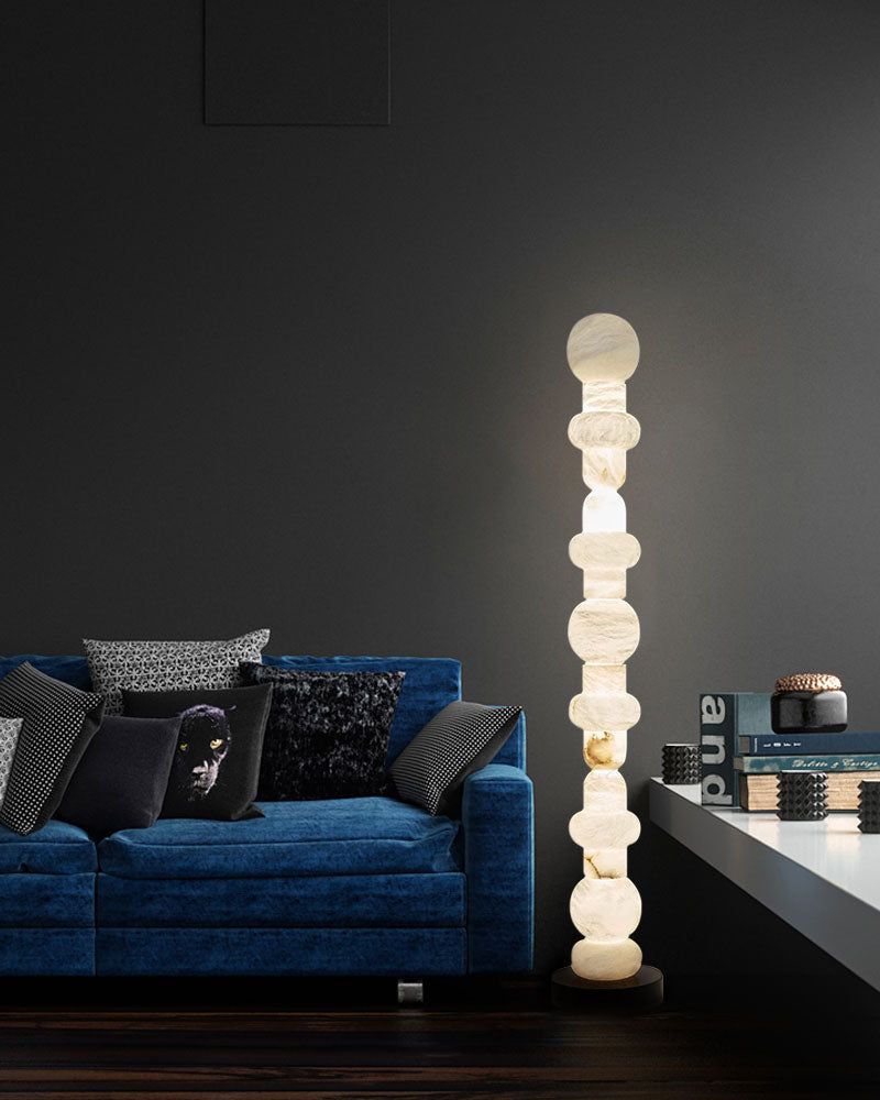 Alabaster floor lamp with geometric design beside blue sofa in modern living room