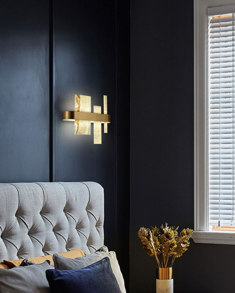 Artistic marble and metal wall sconce enhancing an upscale bedroom ambiance