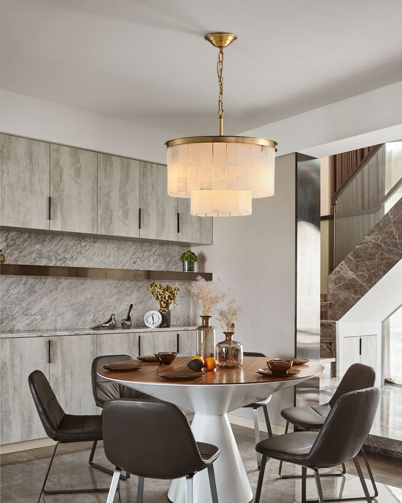 Brass and alabaster chandelier above round dining table in modern kitchen setting